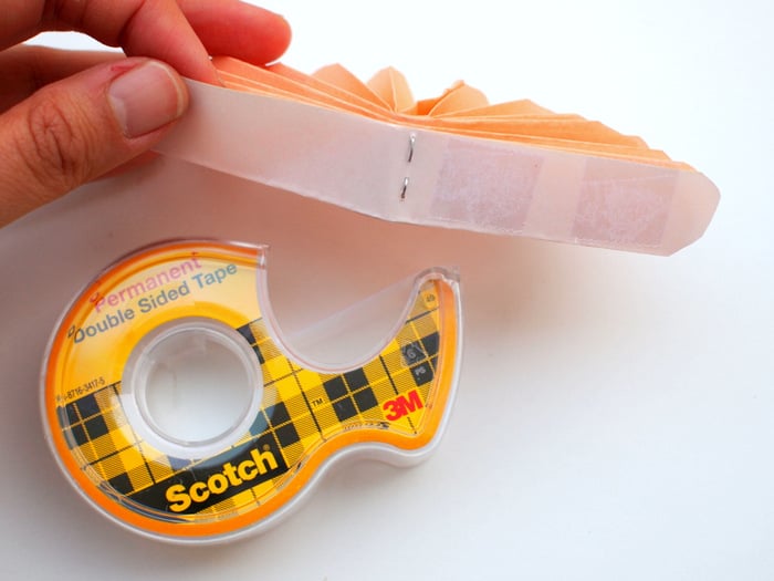 Roll of double sided tape with tape stuck to the inside of a paper flower