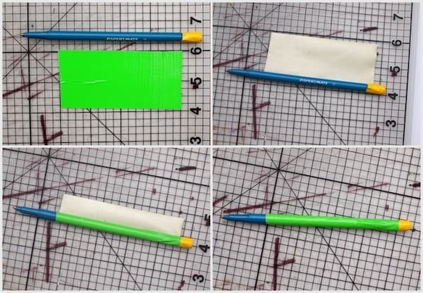 Green duct tape being rolled around the center of the pen