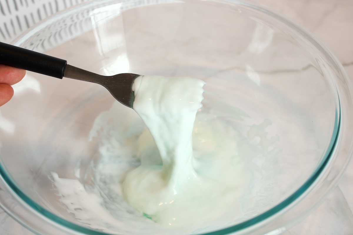 Stirring the laundry detergent and glue mixture with a fork